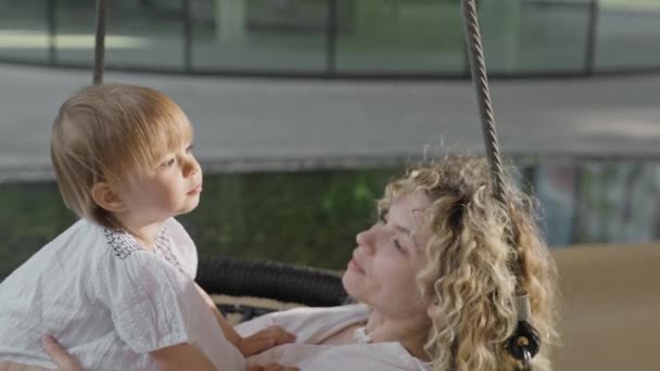 母亲和女儿拥抱在秋千上 家庭价值观 快乐和在儿童游乐场玩乐 — 图库视频影像