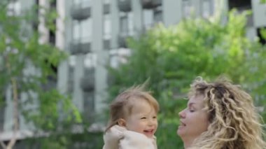 Anne ve kızı kucaklaşıyorlar, sevgi ve bağ kuruyorlar. Aile değerleri, bakım, birlikte iyi vakit geçirmek, mutluluk ve kasabanın arka bahçesinde eğlenmek