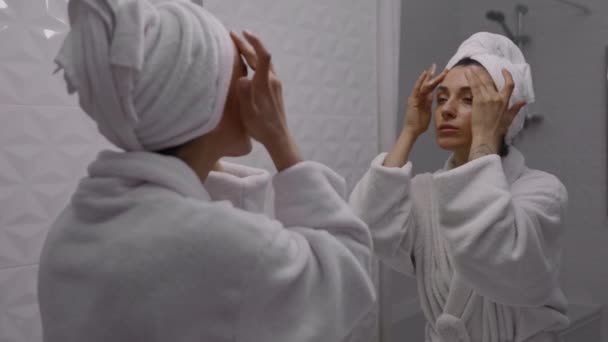 수건으로 머리를 여자는 깨끗하게 거품으로 얼굴을 씻는다 얼굴을 청소하고 피부를 — 비디오