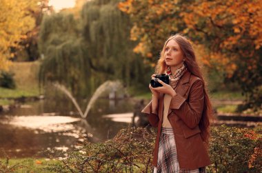 Sonbahar parkında fotoğraf çeken bir kız. Yüksek kalite fotoğraf