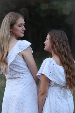 Kız kardeşler dışarıda gülümsüyor. Yüksek kalite fotoğraf