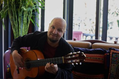 Man emotionally playing the guitar in the interior. High quality photo