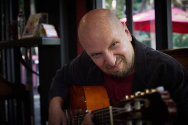 Man emotionally playing the guitar in the interior. High quality photo