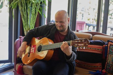 Duygusal Adam iç mekânda Gitar Çalıyor. Yüksek kalite fotoğraf