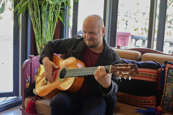 Kapalı bir ortamda tutkuyla gitar çalan bir adam. Yüksek kalite fotoğraf