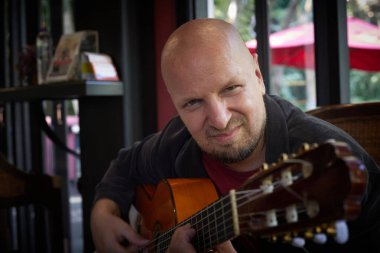 Yakışıklı adam gösteride akustik gitarla müzik yeteneği sergiliyor. Yüksek kalite fotoğraf