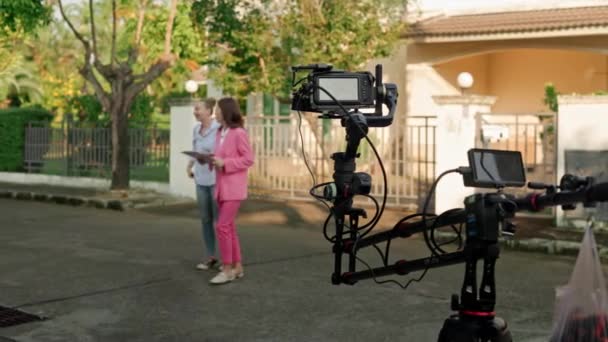 两名妇女正在被一名摄影师用起重机安装的摄像机拍摄 背景是一栋私人房屋 高质量的4K镜头 — 图库视频影像