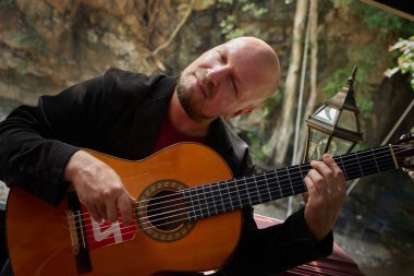 Doğadaki müzik performansı: Adam akustik gitar çalıyor. Yüksek kalite fotoğraf