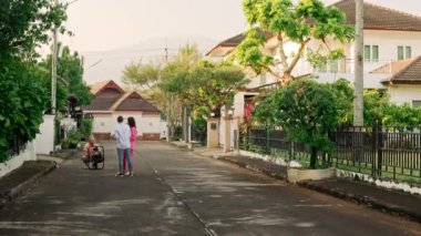 İki kadın, arka planda özel bir ev bulunan çerçeveli kamerayla bir kameraman tarafından kaydediliyor. Yüksek kalite 4k görüntü