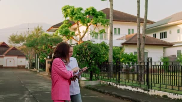 Bir Emlakçı Müvekkili Lüks Bir Mahallede Evlerin Önünde Dikilirken Neşeli — Stok video