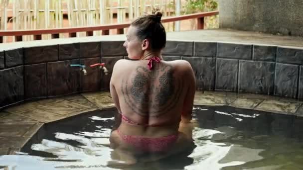 一个身强体壮 背上有斑纹的女人坐在一个炽热的游泳池里 高质量的4K镜头 — 图库视频影像