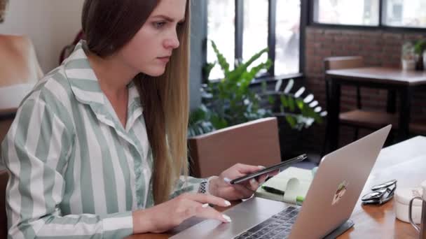 若いウクライナ人女性がカフェでコンピュータを使ってフリーランスの仕事をしている 高品質4K映像 — ストック動画