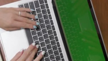 Kamera dönüşüyle, yakın çekim ev ofis çalışma masasındaki dizüstü bilgisayarda yazan profesyonel bir iş kadınının ellerine odaklanıyor. yeşil ekran krom anahtarı. Yüksek kalite 4k
