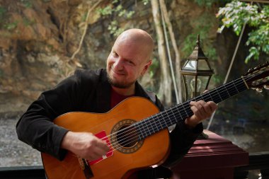 Açık havada tutku ve hünerle gitar çalan bir adam. Yüksek kalite fotoğraf