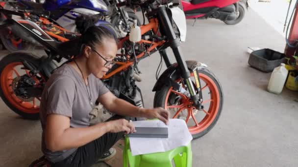 Asijská Žena Obnovení Motoru Oranžové Motocyklu Garáži Vysoce Kvalitní Záběry — Stock video