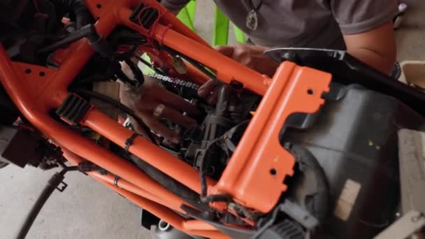 アジアの女性 専門的にオレンジのオートバイのエンジンを修理 高品質の4K映像 — ストック動画