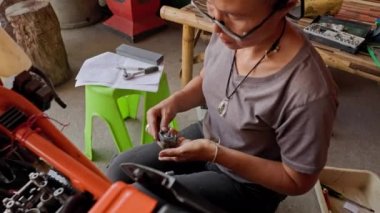 Motosiklet Motor Tamiri Sanatı: 50 yaşında Asyalı Kadın Uzmanı. Yüksek kalite 4k görüntü