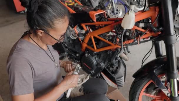Der Werkstatt Eine Jährige Asiatin Repariert Den Motor Eines Orangefarbenen — Stockvideo