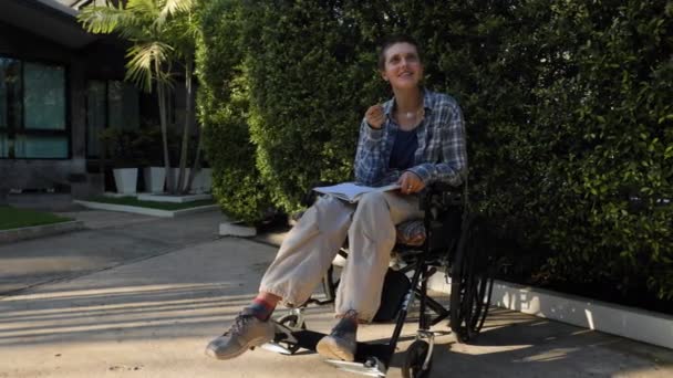 Tekerlekli Sandalyede Kitap Okuyan Bir Otel Parkında Konuşan Genç Bir — Stok video