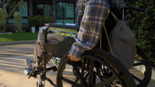 Jovem Movendo Uma Cadeira Rodas Longo Caminho Parque Com Livro — Vídeo de Stock