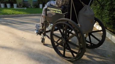 Tekerlekli sandalyedeki engelli yetişkin bir kadın, park yolunun erişilebilirliğinin tadını çıkarıyor, tek başına kitap okuyor, güçlendiriyor ve bağımsızlığını kazanıyor. Yüksek kalite 4k görüntü