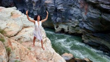 Huzurlu Yolculuk: Doğayı Saran Kadın Nehir kenarında, Görkemli Kayalar ve Şelaleler Arasında Huzur Bulmak Doğal Manzara. Yüksek kalite 4k görüntü