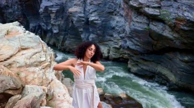 Rocky Riverbank 'in Sahne Ortası' nda Doğanın ve Hareketin Özünü Huzurlu Bir Çevrede Yakalamış Bir Dansçının Zarif Performansı. Yüksek kalite 4k görüntü