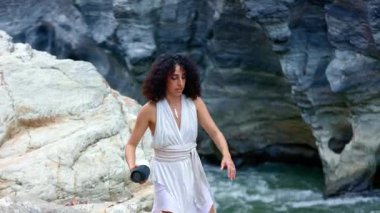 Beyaz Elbiseli Bir Kadın, Rocky Arazisinde Doğal Güzellik ve Duruş Ortasında Anı Yakalıyor. Yüksek kalite 4k görüntü