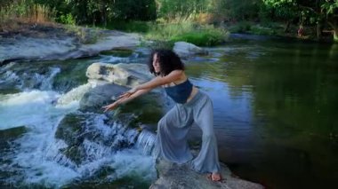 Neşe ve özgürlüğün zarif bir ifadesi, bir kadın kollarını gökyüzüne doğru akarsu ve yemyeşil bir zemin üzerine uzatarak doğayla bir bağ anını vurguluyor. Yüksek kalite