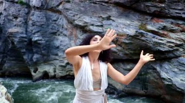 Doğanın Ortasında İfade Eden Dans: Akan Beyaz Giysili Bir Kadın Şelale 'de Hareket ve Duyguyu Kutluyor, Doğal Dünya ile Kanal Bağlantısı. Yüksek kalite 4k görüntü