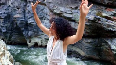 Nehir kenarındaki Huzurlu Dans: Çarpıcı Doğal Manzara Ortasında Zarif İfade Hareketi Doğayla İlişkinin Özünü Yakalıyor. Yüksek kalite 4k görüntü