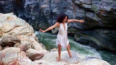 Bir Zarif Dansçı Görkemli Kaya oluşumlarının ortasında Serene Nehri 'nin yanında, Doğanın ve Hareketin Özünü Ahenk içinde Yakalıyor. Yüksek kalite 4k görüntü
