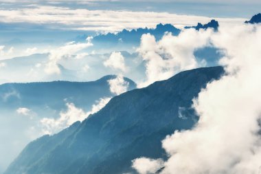 Bulutların üstünde tepeleri olan İskoçya manzarası. Büyük kayaların ve alçak bulutların arasındaki dağların olduğu güzel bir manzara. Ulusal park Tre Cime di Lavaredo. Dolomiti Alpleri, Güney Tyrol, İtalya, Avrupa