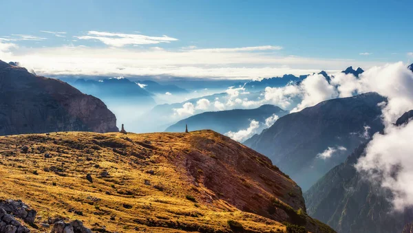 Bulutların üstünde zirveleri olan dağ manzarası. Tre Cime di Lavaredo Ulusal Parkı. Dolomitler, Güney Tyrol, İtalya, Avrupa. Doğa güzelliği, arka plan konsepti