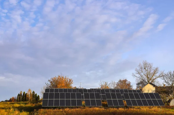 雲と黄色の秋の木と青い空の背景に光電電池 太陽電池パネル 代替エネルギーの概念 — ストック写真