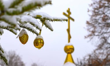 Ortodoks Haçı 'nın arka planında süslemeleri olan bir Noel ağacı dalı. Ortodoks Kilisesi. Kış Noel 'dir. Koni ve haç. Ortodoksun pt 'i.