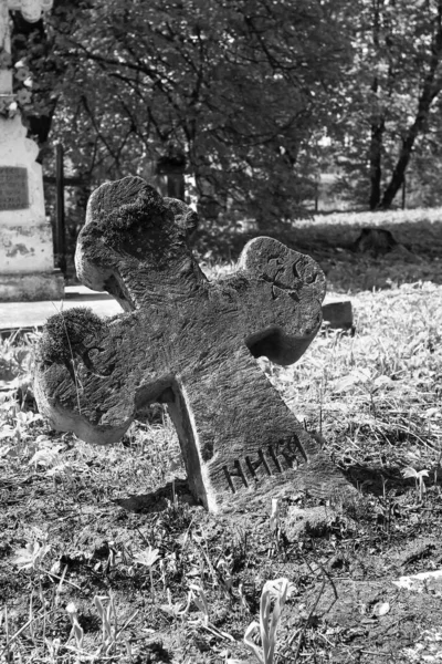 Old cemetery. Old neglected, mutilated figures of saints and crosses on graves. Remains of tombstones. Vandalism, destruction, destruction.