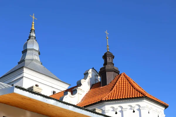 古代正教会の修道院の円錐形のドームは ウクライナ西部の深い青い空に対して十字架で修復されました 黄色いマリーゴールドの花 正統主義とキリスト教信仰の概念 — ストック写真