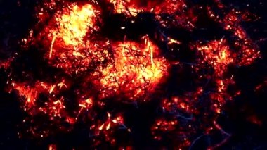 Karanlıkta yanan şenlik ateşinin parlak alevi akşam gökyüzünün arka planında. Alevler içinde yanan dallar, alevlerin dilleri. Çiftçi alevi takip eder. Tarım İşleri.