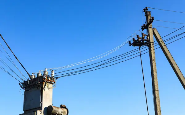 エネルギーと技術 青い空に対して送電線ケーブル 変圧器 電話線を持つ電柱 — ストック写真