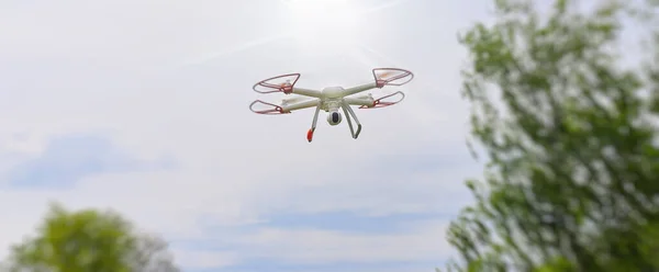 A drone with a high resolution digital camera in the air. The flying camera takes photos and videos. A drone with a camera captures the sky. Aerial photography and videography.