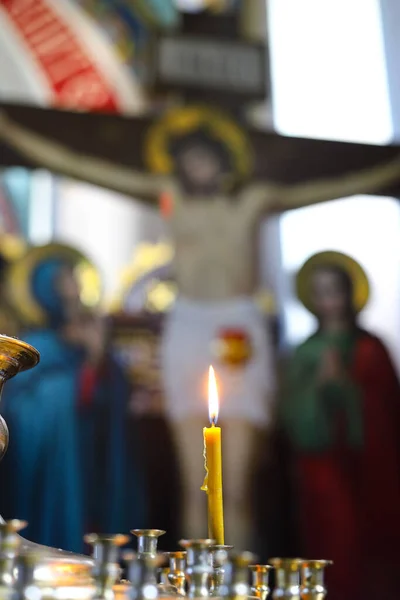 教会でろうそくを燃やし 十字架 ゴルゴタ 正教の概念 ぼやけた焦点で十字架の背景に蝋燭を灯しました — ストック写真
