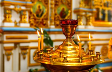 Ortodoks Kilisesi. Hıristiyanlık. Mumlar bir Ortodoks kilisesinde ayin sırasında şamdanlarda yanar. Seçici odak, yüzeysel alan derinliği.