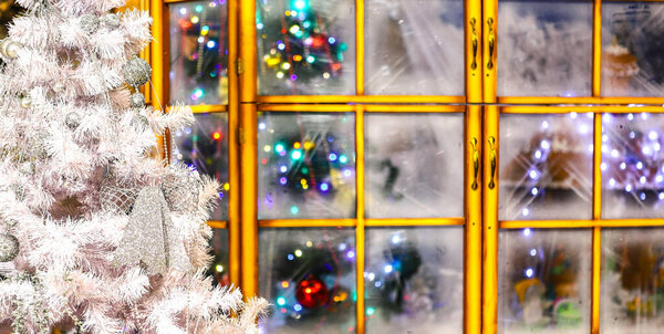 Празднично украшенная декоративная елка у окна комнаты и вечернего света, Счастливого Рождества и Нового года, счастливых праздников, счастливого момента и времени празднования.