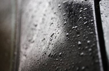 Sabah çiğ damlaları ya da vücut yüzeyine yağan yağmur damlaları, araba aynası. Sığ odak derinliği, makro.