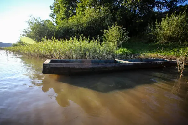 Güneşli bir günde nehir kıyısında demirli eski ahşap balıkçı tekneleri. Beyaz bulutlu güzel bir gökyüzü. Kırsal bölgelerde dolaşmak.