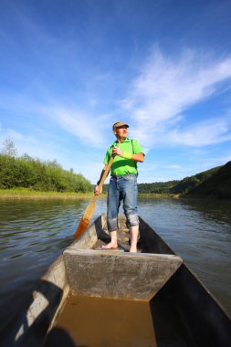 Bir adam eski bir tekneyle seyahat eder. Kürek çekiyor. Aktif eğlence, memleketine bir gezi. Batı Ukrayna 'da bir nehir, Avrupa.