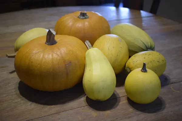 Yellow squashes and orange pumpkins on table