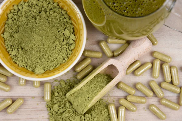 Kratom Mitragyna Specosa tozu, kapsül ve en iyi görünüm görüntülerini iç. Yeşil kratom tozu, kapsül ve içecek stok fotoğrafının üstünde hayat var. Kratom bitkisel ilaç stoku görüntüleri