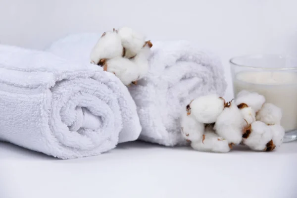White towels and cotton flowers spa still life stock photo images. Spa and wellness setting with towels, candles and cotton flowers on white background. White spa-concept stock images